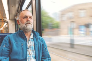 Otobüste ya da tramvayda mavi ceketli mutlu sakallı adam. Yaşam tarzı kavramı