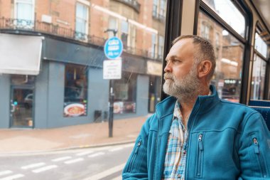 Otobüste ya da tramvayda telefonla konuşan mavi ceketli sakallı bir adamın portresi. Yaşam tarzı kavramı