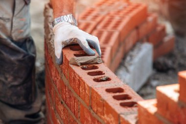 hand of Bricklayer working leveling on curved wall clipart