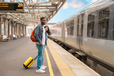 Tren istasyonunda tren bekleyen çift. Buluşmalar, veda eşleri, arkadaşlar. Seyahat yaşam tarzı konsepti