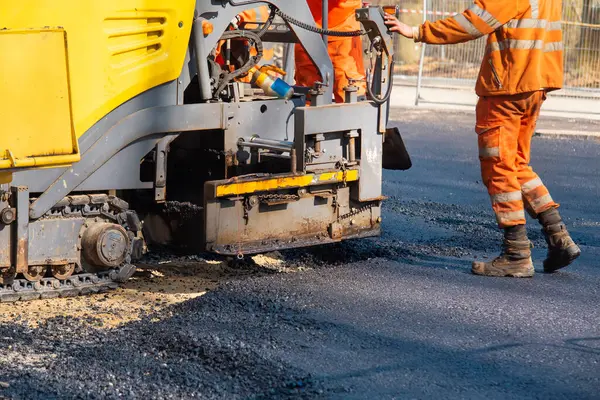 Yeni yol inşaat sahası döşeyen operatörle asfalt paver sıcak asfalt asfalt