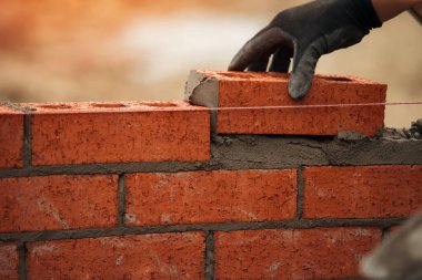 Duvarcının, inşaat alanında tuğla döşeyen Masonry Trowel ile yakın çekimi