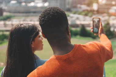 Güneşli bir günde Şehir Parkı 'nda selfie çeken genç çift.