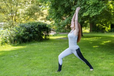 Güneşli bir günde Yeşil Park 'ta Yoga Çalışan Kadın