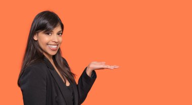 Siyah Ceketli Genç Kadın Gülümseyen ve Sunan Portakal Arkaplanda Kopya Boşluğu