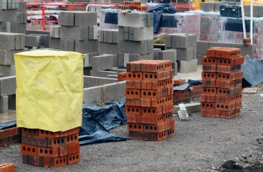 İnşaat alanında kırmızı tuğla ve beton blokları yığını