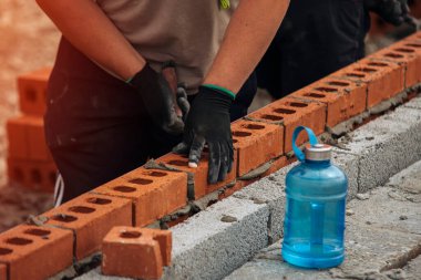 Tuğla döşeyen inşaat işçisi Gün boyunca eldiven takıyor
