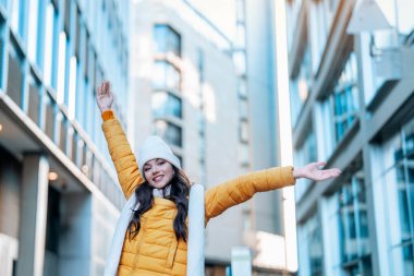 Sarı Ceketli Kadın ve Beyaz Şapkalı Kadın Bulutlu Gün 'de Şehrin tadını çıkarıyor