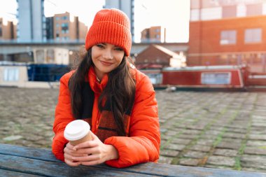 Soğuk bir günde Nehir kenarında Ilık İçkinin Tadını Çıkaran Genç Kadın