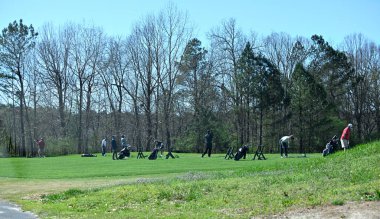 Golf sahasındaki insanlar Winder, Georgia, ABD 'deki golf sahasında golf toplarına vurmaya çalışıyorlar..