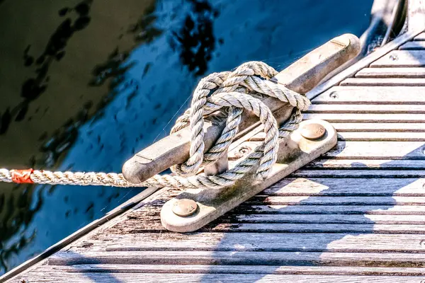 close up of yacht mooring rope tied around cleat in harbour