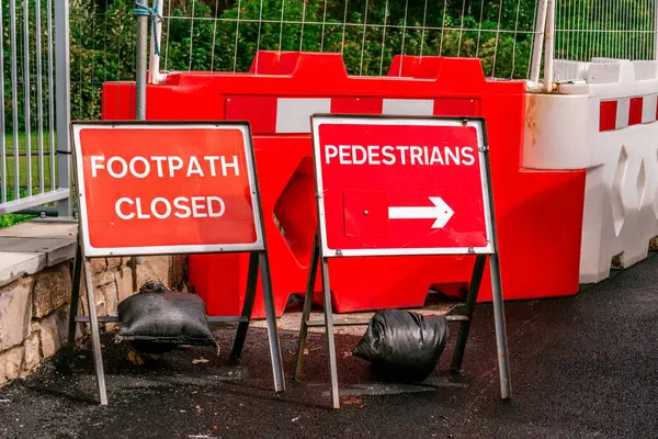 Walking Past Street Roadworks Safety Barrier with Pedestrians Forbidden Closed Walkway Sign