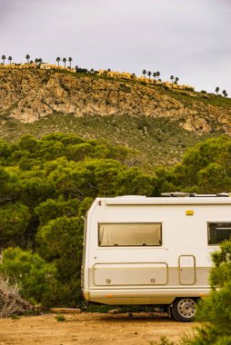 Camping on mediterranean coast in Spain. Camper vehicle on beach, sea shore.
