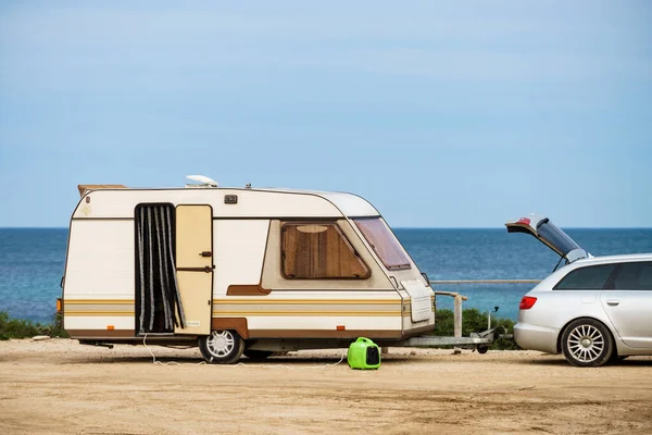 Caravan trailer camping on seashore. Vacation trip with mobile home.
