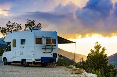 Kapalı tenteli bir kamp aracı ve Fransız dağlarında sandalyeli bir turist masası. Doğada kamp yapmak. Tatiller ve karavanla seyahat.