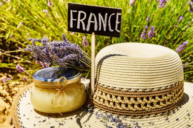 Yaz şapkası, ballı kavanoz ve üzerinde taze lavanta tarlası arka planına karşı Fransa imzası olan tabela. Provence 'de Fransız tatili için çekim gezisi.