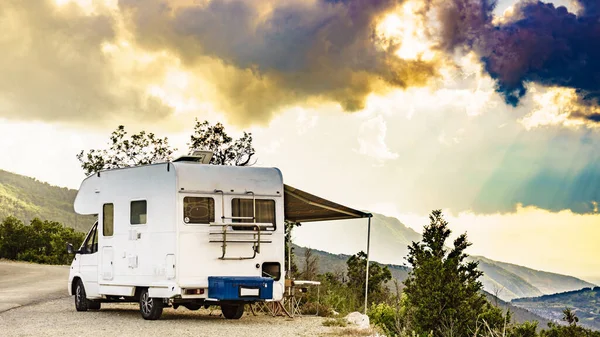 stock image Camper vehicle with roll out awning and tourist table with chairs in french mountains. Camping on nature. Holidays and travel with motor home.