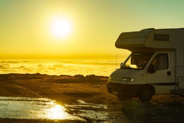 Karavan bulutların üstünde gün doğumunda. Portekiz 'in dağ doğasında bir karavan kamp arabası. Kamp aracıyla macera..