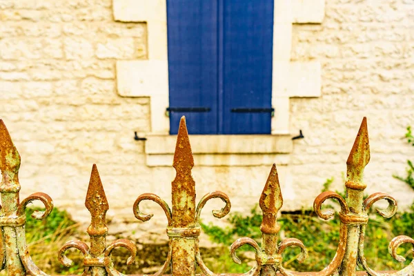 古い金属製のフェンスと伝統的なフランスの石の壁に暗い青のシャッターウィンドウを塗装 — ストック写真