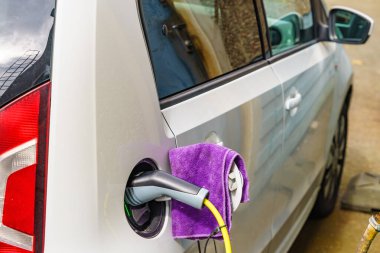 Şarj istasyonunda elektrik prizi olan elektrikli bir araba. Ekolojik ulaşım. Otomotiv teknolojisi kavramı.