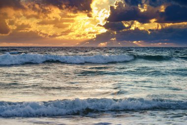 Gün batımı, deniz üzerindeki güneş ışığı, fırtınalı bulutlar. Akşamları deniz manzarası.