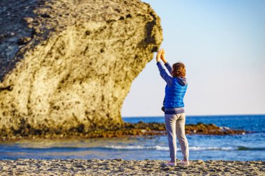 Cabo de Gata Nijar Doğal Parkı 'nda Monsul sahilinde yürüyen bir kadın. Almerya kıyıları. Turist çekmek için büyük lav oluşumu.