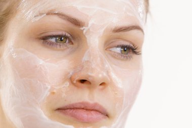 Yüzünde krem kozmetik, maske ve nem olan genç bir kadın. Güzellik tedavisi. Cilt bakımı.