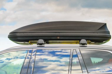 Arabanın çatısında bagaj ya da kargo kutusu var. Seyahat, aile tatili. Ulaşım için aksesuarlar.