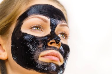 Yüzüne karbonhidrat maskesi takan genç bir kadın. Genç kız yağlı cildiyle ilgileniyor, gözenekleri temizliyor. Spa tedavisi. Cilt bakımı.