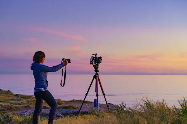 日落时带着两台相机拍摄自然旅行照片的女游客 — 图库照片