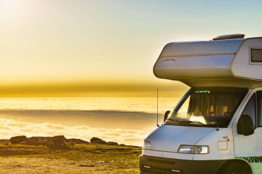 Karavan bulutların üstünde gün doğumunda. Portekiz 'in dağ doğasında bir karavan kamp arabası. Kamp aracıyla macera..