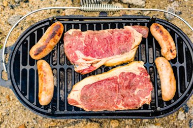 Et ve sosis ızgarada. Barbekü yemeği, yaz yemeği..