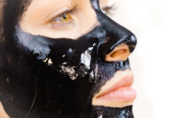 Young woman with cosmetic on face, carbo detox black peel off mask. Spa treatment. Skincare.