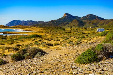 Sahilde kamp yapan karavanlı deniz manzaralı bir karavan. İspanya Murcia bölgesi, Calblanque Bölgesel Parkı.