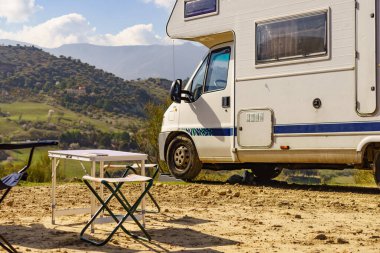 Camp equipment chairs and table at caravan. Wild camping on nature. Holidays and traveling in motor home.