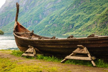 Eski ahşap tekne viking Norveç doğa deniz kıyısı üzerinde. Dağlar ve fiyort Sognefjord. Turizm ve seyahat kavramı