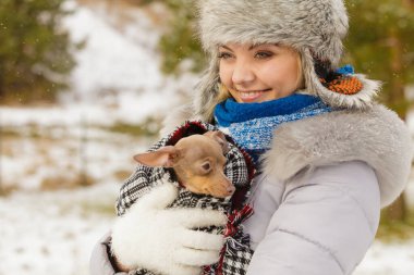 Genç bir kadın soğuk kış gününde en iyi arkadaşını sıcak battaniye eşarbına sardı. Hayvan koruma programı. Evlat edinme kavramı
