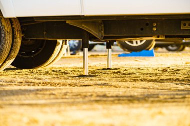 Kamp için otomatik seviye sistemi. Hidrolik sabit bacak kullanımda. Arkadaki karavan için mavi rampa tıkanıklığı.