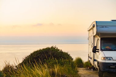 Akdeniz kıyısında şafak sökerken İspanya 'da bir karavan. Deniz kıyısında kamp yapmak. Karavanda tatil gezisi.