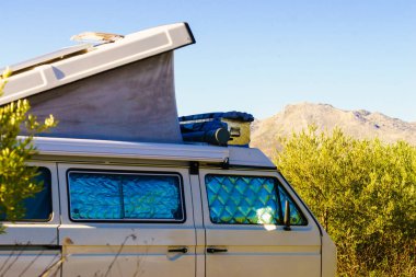 Çatı üstü çadırı olan bir karavan ve doğada kamp yapan bir termal pencere. Tatil gezisi ve gösteriş budalası.