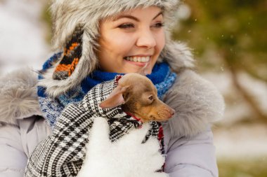 Genç bir kadın soğuk kış gününde en iyi arkadaşını sıcak battaniye eşarbına sardı. Hayvan koruma programı. Evlat edinme kavramı