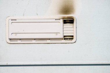 Kamp arabası detayı. Şebeke, buzdolabının havalandırma plakası dumanla karartılmış. Gaz problemi.