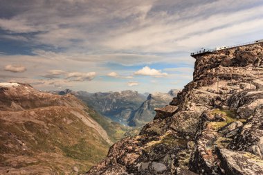 Dalsnbba bölgesinden Geirangerfjord ile panoramik dağlar manzarası. Geiranger Skywalk dağdaki platformu uzaktan görüyor. Norveç.