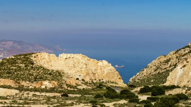 Denizde gemisi olan kayalık kıyı manzarası. Mesa Roldán 'dan görüntü. Cabo de Gata Nijar, Almerya kıyıları, İspanya.