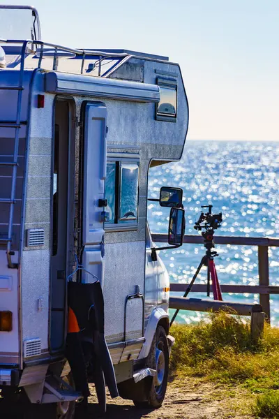 Kamp aracı karavanı sahilde kamp yapıyor, sörf kıyafetleri dışarıda asılı. İspanya Murcia bölgesi, Calblanque Bölgesel Parkı.