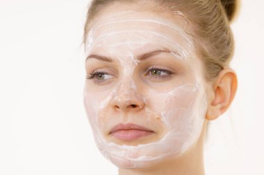 Yüzünde krem kozmetik, maske ve nem olan genç bir kadın. Güzellik tedavisi. Cilt bakımı.