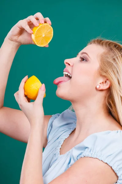 Healthy diet, refreshing food full of vitamins. Woman drinking juice from juicy fruit, yellow lemon