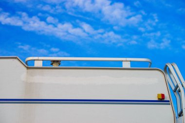 Karavanın çatısı mavi gökyüzüne karşı. Motorlu ev detayı.