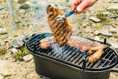 Et ve sosis ızgarada. Barbekü yemeği, yaz yemeği..