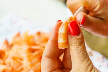 Deniz ürünleri, okyanus yemekleri. Çiğ karides soyan kadın eller. Karides pişirmeye hazırlanılıyor..